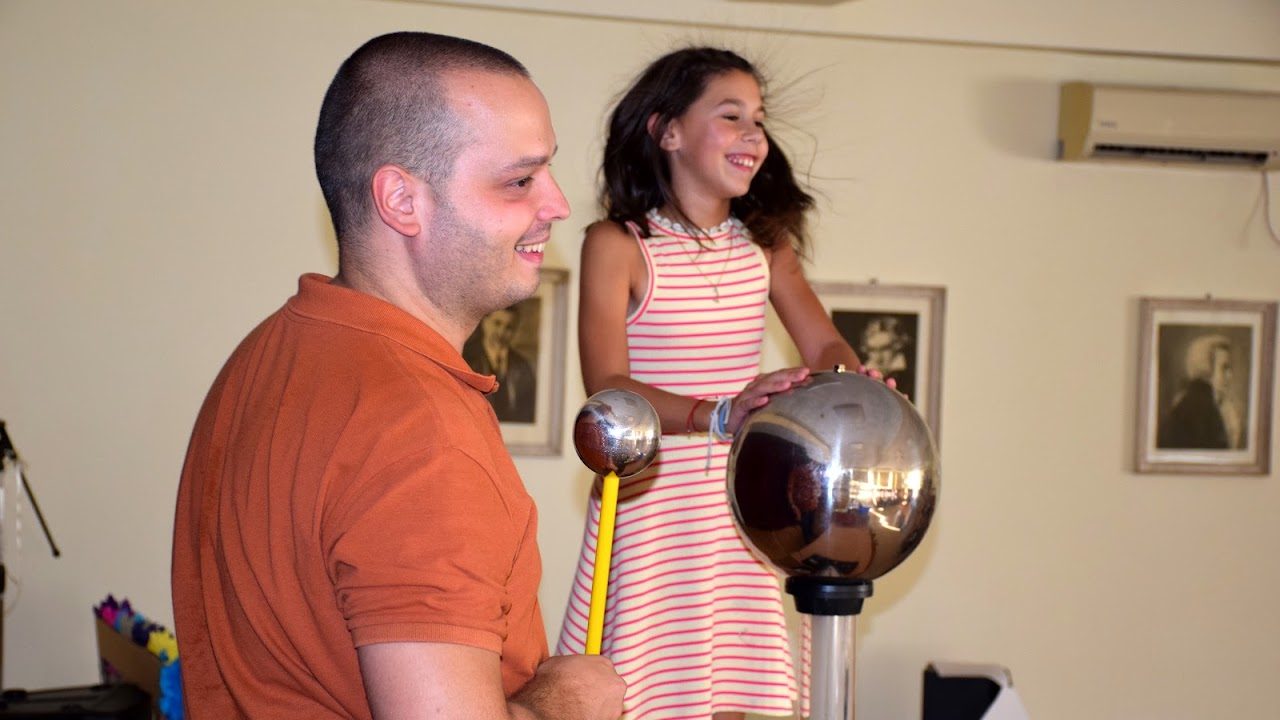Devojčici se diže kosa dok dodiruje Van de Graafov generator